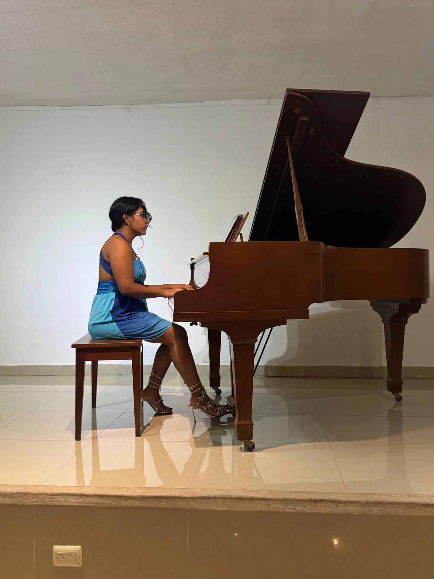 A young pianist plays the grand piano in the academy's hall.