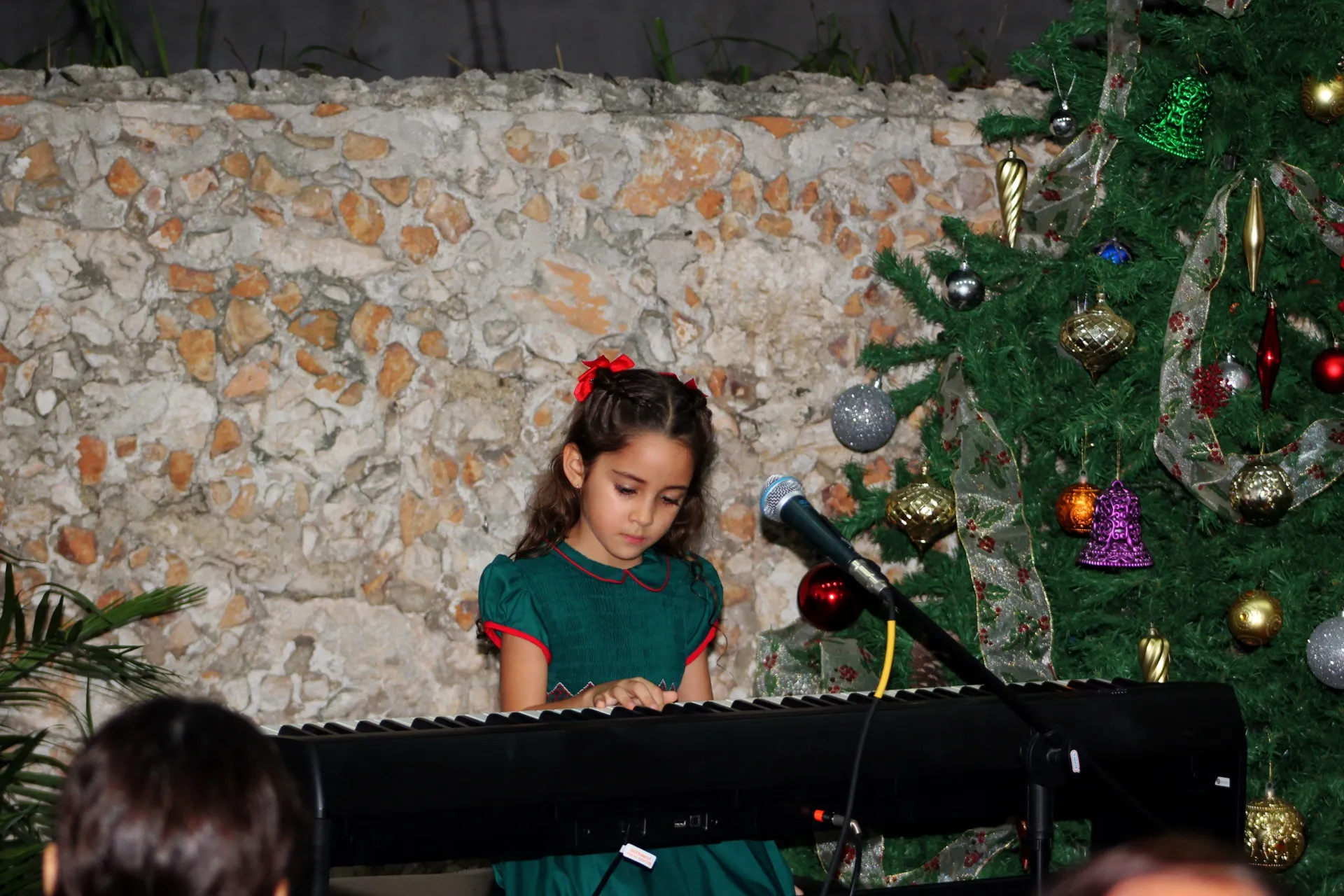 Una niña toca el teclado en el recital navideño de la academia.