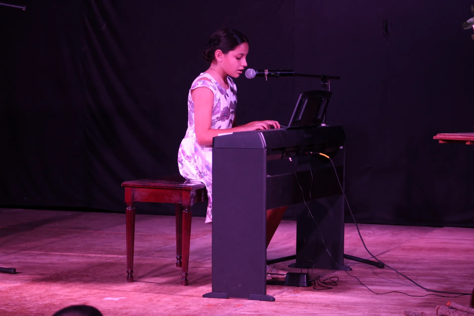Una alumna interpreta una pieza sobre el escenario durante un recital.